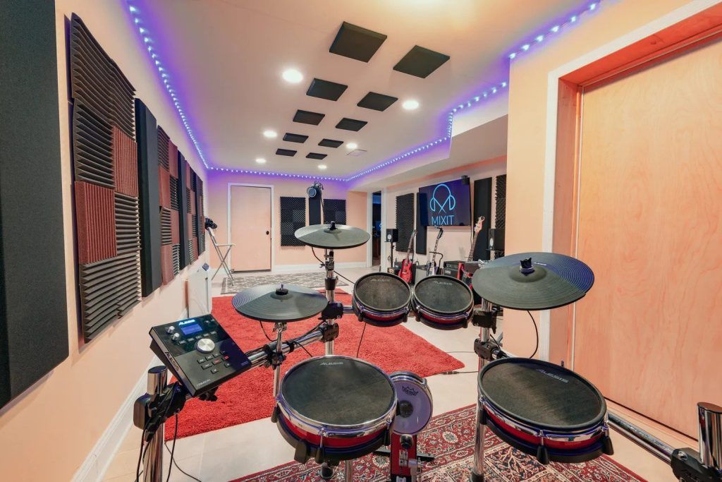 The interior of Mixit Studios featuring an electronic drumse in a brightly lit room with a red carpet.